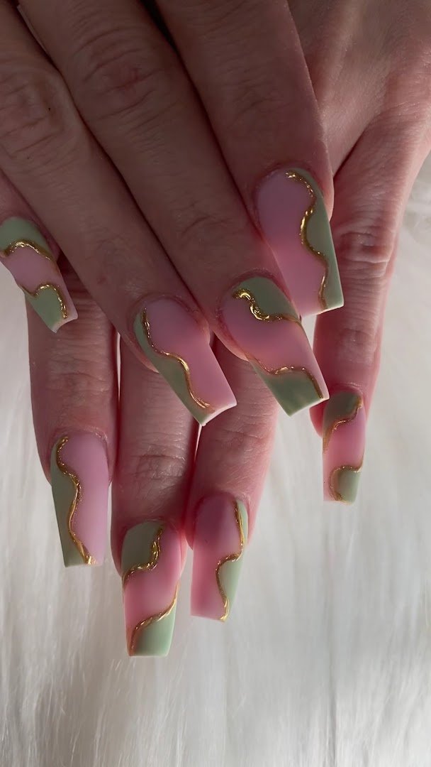 Close-up of manicured nails beside colorful gel polish bottles.